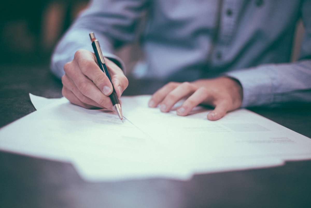Signed documents and a laptop on a conference table